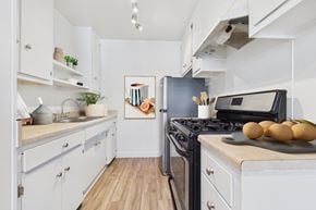 Los Angeles apartment for rent - A kitchen with a black stove top oven and a black fridge.