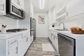 Los Angeles apartment for rent - A modern kitchen with white cabinets and a wooden floor.