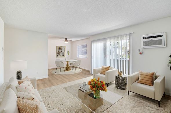 Los Angeles apartment for rent - A living room with a white couch, a coffee table, and a dining table.