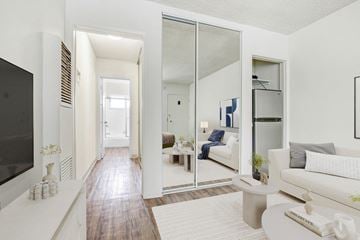 Santa Monica apartment for rent - A modern living room with a white couch and a television on the left side.