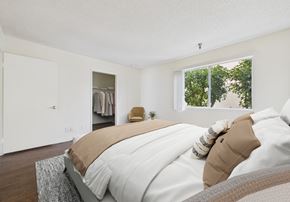 Northridge apartment for rent - A bedroom with a large bed and a window overlooking trees.