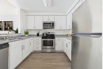Northridge apartment for rent - A modern kitchen with stainless steel appliances and white cabinets.