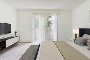 Northridge apartment for rent - A bedroom with a large bed and a television on the wall.