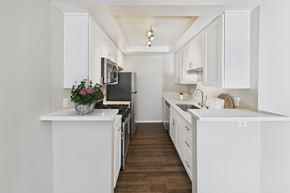 Los Angeles apartment for rent - A kitchen with white cabinets and a black fridge.