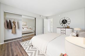 Los Angeles apartment for rent - A bedroom with a large bed and a wardrobe with clothes hanging.