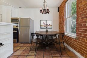 Los Angeles apartment for rent - A kitchen with a refrigerator, a dining table with chairs, and a painting on the wall.