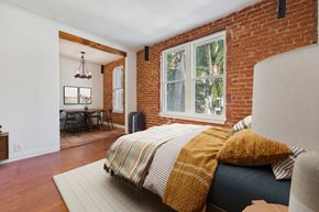 Los Angeles apartment for rent - A bedroom with a bed covered in a yellow and white striped comforter.