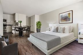 Los Angeles apartment for rent - A bedroom with a large bed and a dining area in the background.