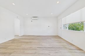 Los Angeles apartment for rent - A spacious room with wooden flooring and white walls.