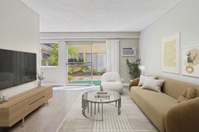Torrance apartment for rent - A living room with a brown couch, a glass coffee table, and a flat-screen TV.