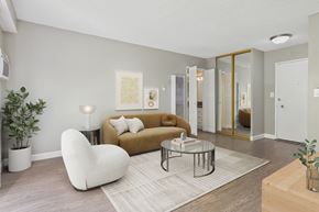 Torrance apartment for rent - A living room with a white bean bag chair, a brown couch, and a glass coffee table.