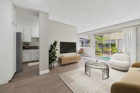 Torrance apartment for rent - A modern living room with a television, a chair, and a potted plant.