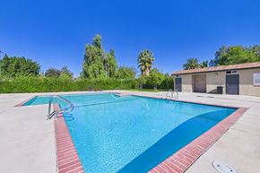 Canoga Park apartment for rent - A swimming pool with a red border and a clear blue sky in the background.