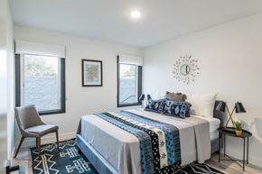 Pasadena apartment for rent - A bedroom with a large bed and a chair by the window.