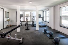 Pasadena apartment for rent - A spacious gym with a variety of equipment including a treadmill, a rowing machine, and a bench press.