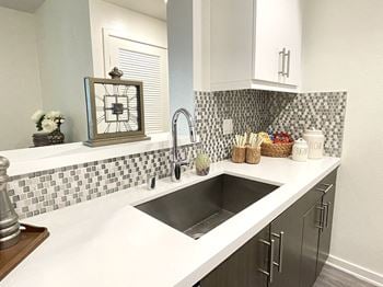 A kitchen with a black and white checkered backsplash.