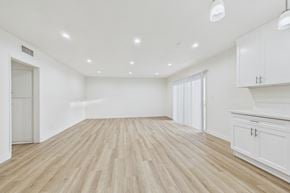 Burbank apartment for rent - A spacious room with wooden flooring and white walls.