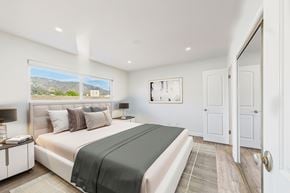 Burbank apartment for rent - A bedroom with a large bed and a view of the mountains outside the window.