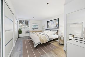 Santa Monica apartment for rent - A bedroom with a large bed and a fridge in the corner.