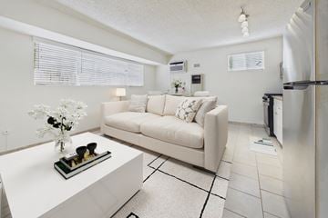 Los Angeles apartment for rent - A white couch with a vase of flowers on a coffee table in a modern living room.