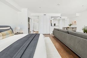 Los Angeles apartment for rent - A long, narrow bedroom with a bed on the left and a couch on the right.
