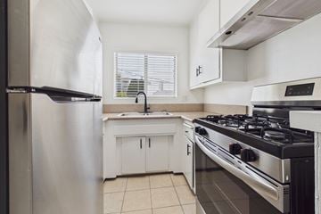 Los Angeles apartment for rent - A modern kitchen with a stainless steel refrigerator, a stove, and a sink.