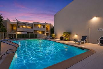 Torrance apartment for rent - A swimming pool in a residential area with a building in the background.