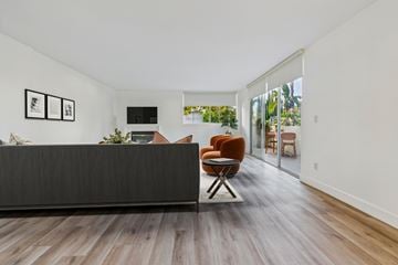 Sherman Oaks apartment for rent - A living room with a brown chair and a black couch.