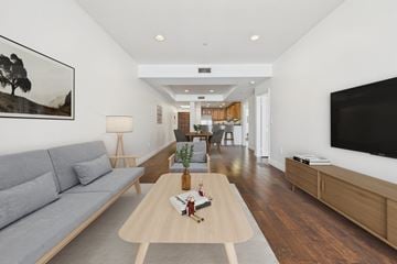 Sherman Oaks apartment for rent - A modern living room with a grey sofa and a wooden coffee table.
