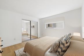 Sherman Oaks apartment for rent - A bedroom with a bed and a mirror on the wall.