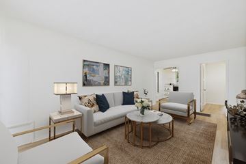 Long Beach apartment for rent - A living room with a white couch, a coffee table, and a painting on the wall.