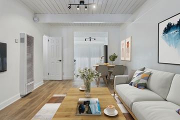 Culver City townhouse for rent - A modern living room with a white sofa, a wooden coffee table, and a painting on the wall.