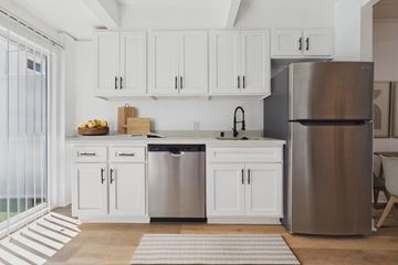 Culver City townhouse for rent - A modern kitchen with white cabinets and stainless steel appliances.