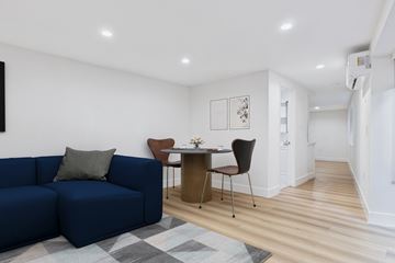 Sherman Oaks apartment for rent - A blue couch sits in a living room with a brown chair and a small table.