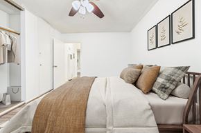 Sherman Oaks apartment for rent - A bedroom with a bed covered in a white comforter and a brown throw.