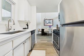 Valley Village apartment for rent - A modern kitchen with white cabinets and a wooden floor.