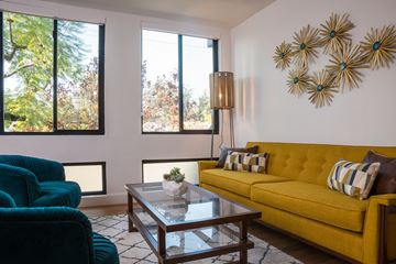 Highland Park apartment for rent - A living room with a yellow couch and a glass coffee table.