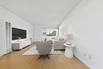 North Hollywood apartment for rent - A modern living room with a grey chair and a white side table.