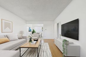 North Hollywood apartment for rent - A living room with a grey couch, a coffee table, and a flat screen TV mounted on the wall.
