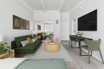 Van Nuys apartment for rent - A living room with a green couch and a television on the wall.