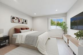 Reseda apartment for rent - A bedroom with a large bed and a window overlooking a tree.