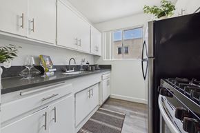 Van Nuys apartment for rent - A kitchen with white cabinets and a black refrigerator.