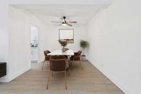 Van Nuys apartment for rent - A dining room with a white table and brown chairs.