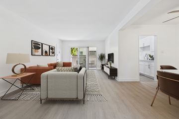 Van Nuys apartment for rent - A living room with a grey sofa and a brown armchair.