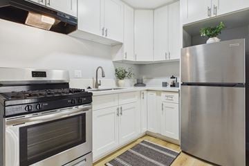 Van Nuys apartment for rent - A modern kitchen with white cabinets and stainless steel appliances.