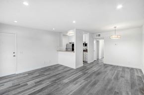Reseda apartment for rent - the living room and kitchen in a new home with white walls and wood flooring