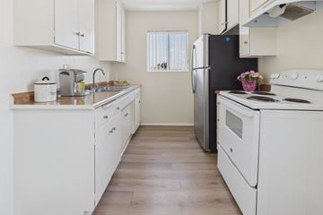 Panorama City apartment for rent - A kitchen with white appliances and wooden floors.
