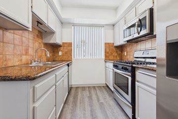 Los Angeles apartment for rent - A kitchen with a brown counter top and white cabinets.