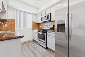 Los Angeles apartment for rent - A modern kitchen with stainless steel appliances and white cabinets.