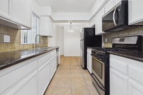 Los Angeles apartment for rent - A kitchen with black appliances and white cabinets.